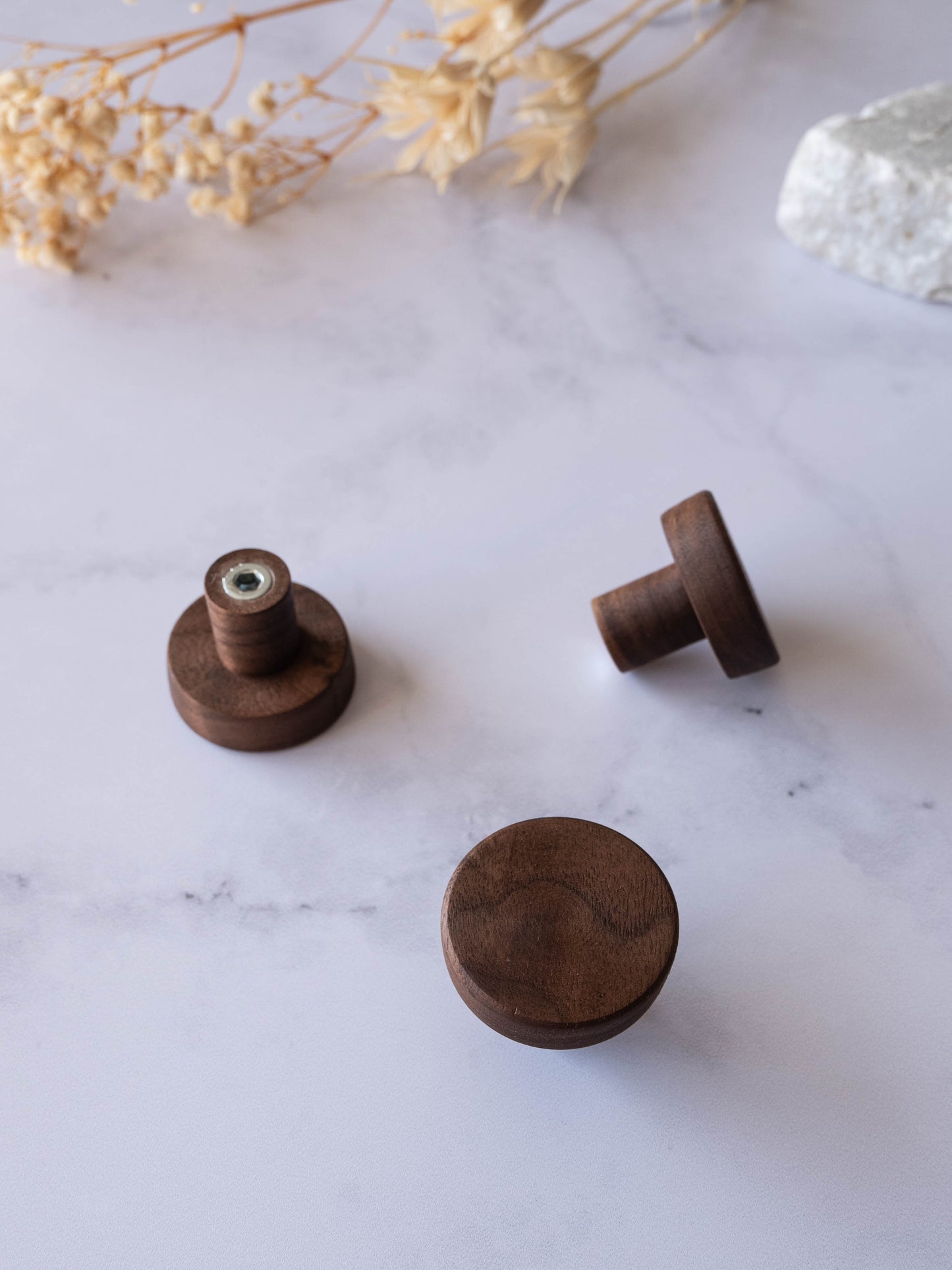 Boutons d’armoire en noyer naturel sur surface en marbre, poignées rondes minimalistes pour meubles.